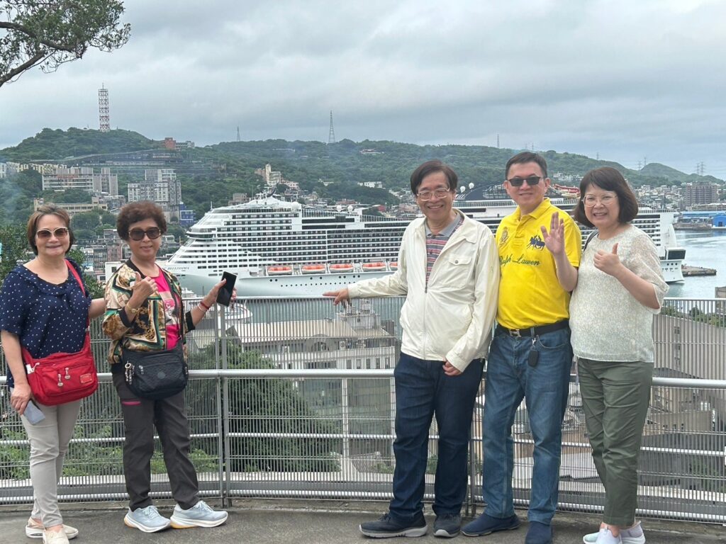 A photo with our tablemate, the lady from Keelung, at the tall tower in Keelung Port.