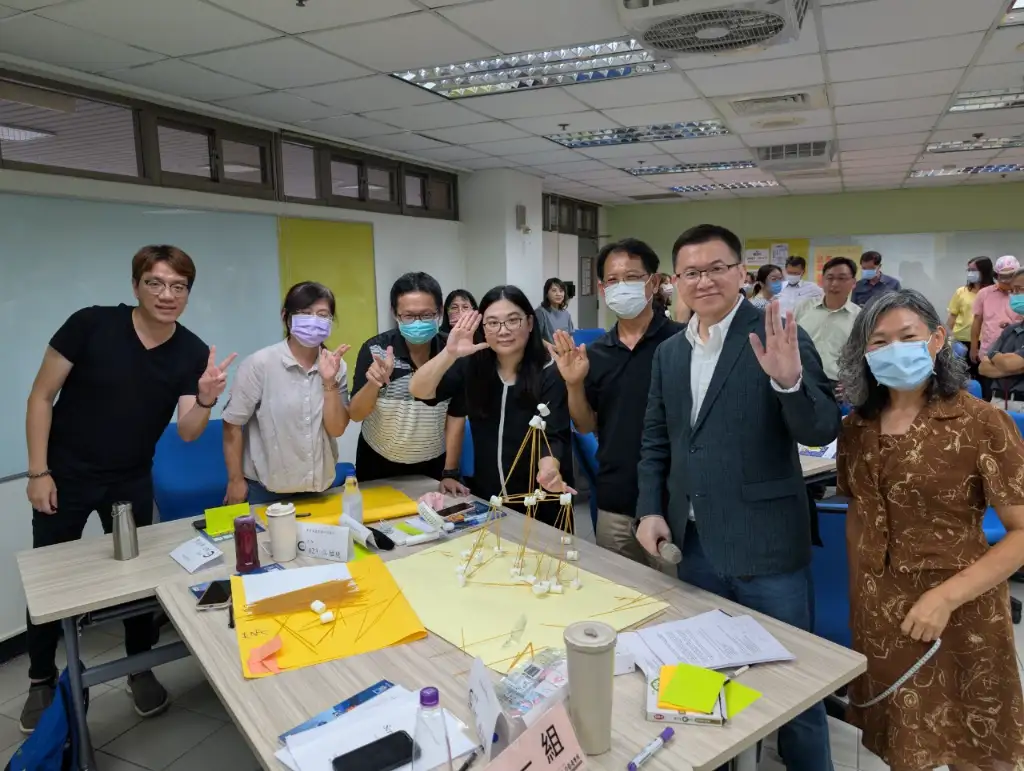 A group photo of the first group of supervisors with their tall tower