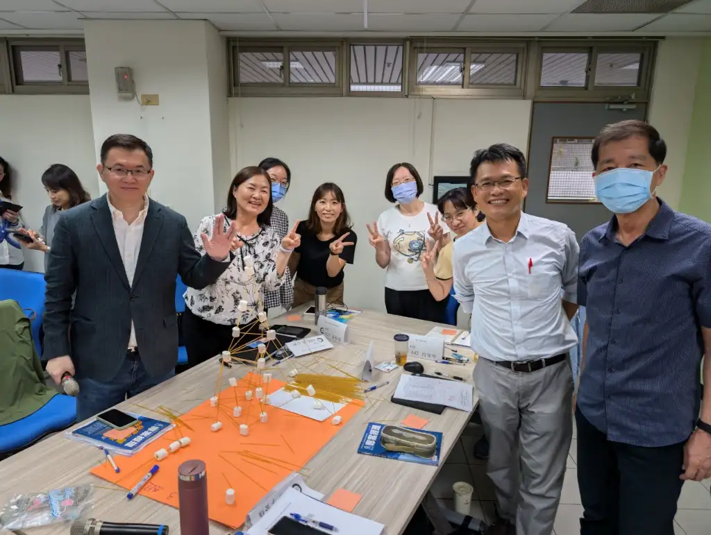 A group photo of the third group of supervisors with their tall tower