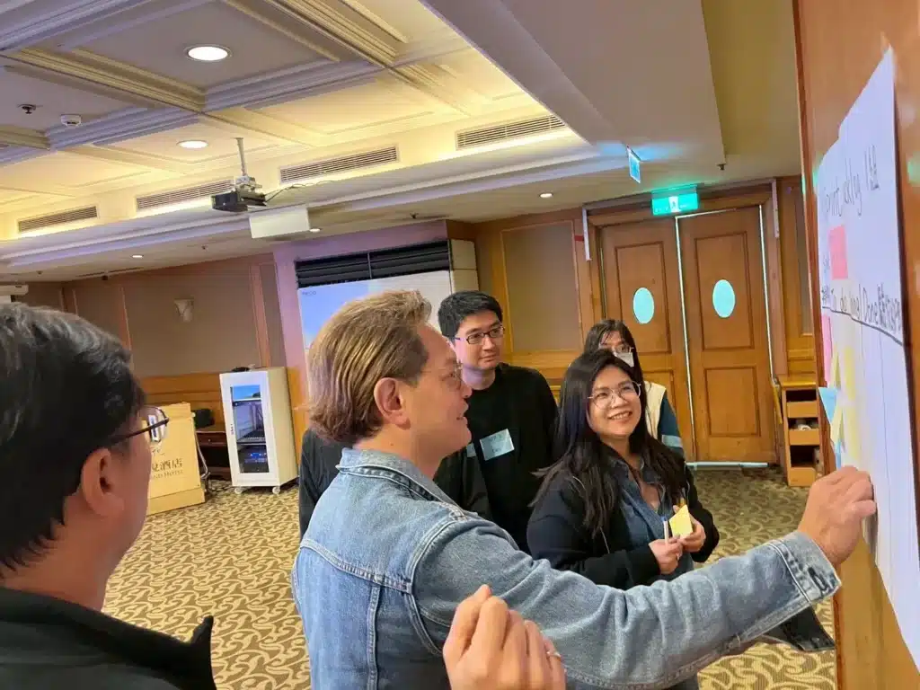 Figure 3. Chairman Su O-Chuan works with a team to place items on the Scrum Board during the workshop.