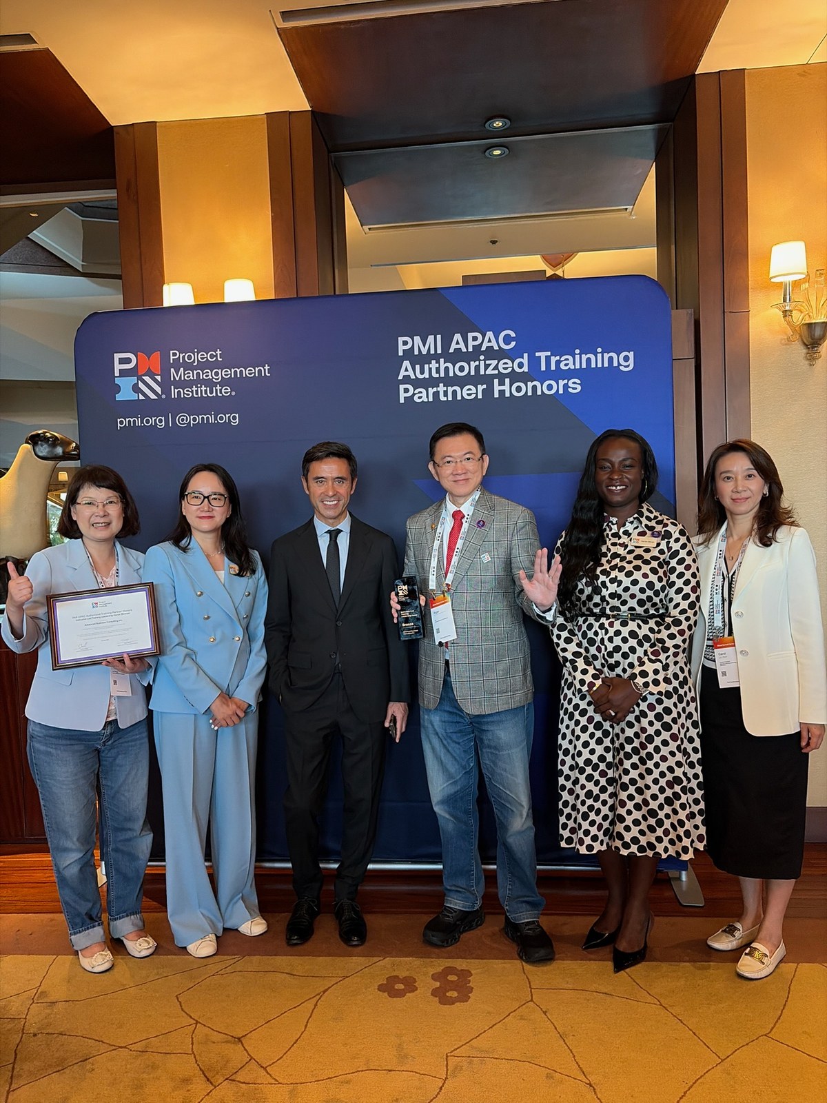 Roger Chou holding the award with PMI senior leaders